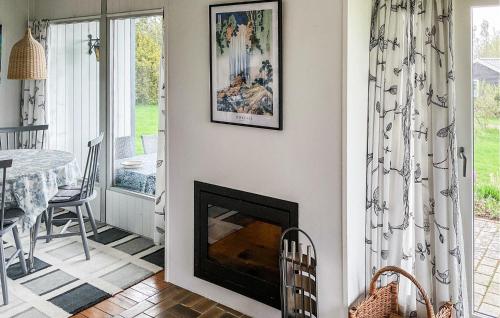 a living room with a fireplace and a dining room table at Cozy Home In Ølsted With Kitchen in Ølsted