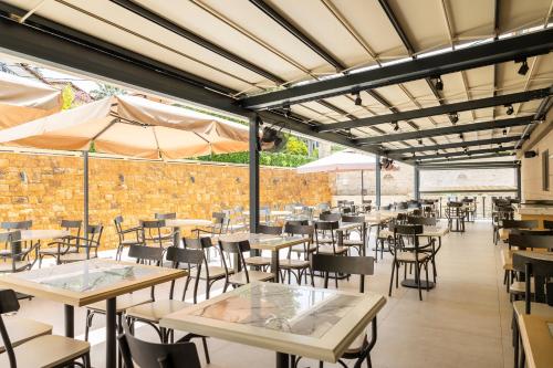 a restaurant with tables and chairs and a brick wall at ARA Luxury Suites in Polykhrono