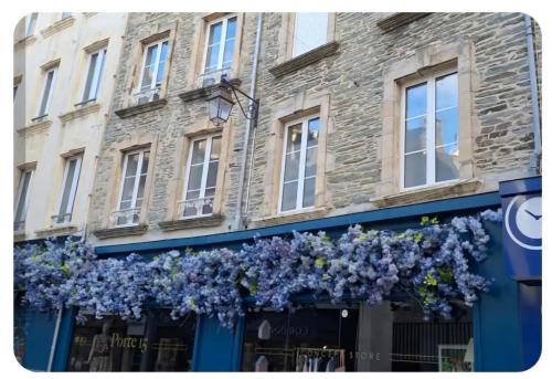 un magasin avec des fleurs bleues sur la façade d'un bâtiment dans l'établissement La Débarque, à Cherbourg en Cotentin