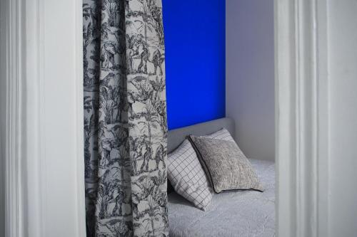 un lit avec un rideau et un oreiller dans une chambre dans l'établissement Charmant deux pièces au coeur du Marais, à Paris