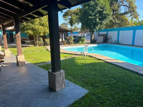 a pole in the grass next to a swimming pool at Pousada Você No Guarujá in Guarujá