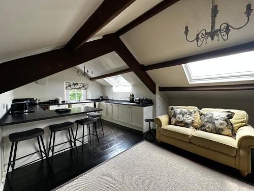 a kitchen with a couch and some bar stools at Penthouse apartment in Cockermouth