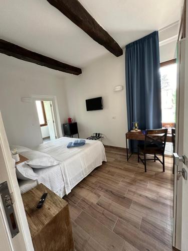 a bedroom with a bed and a desk and a television at Il Glicine in Parma