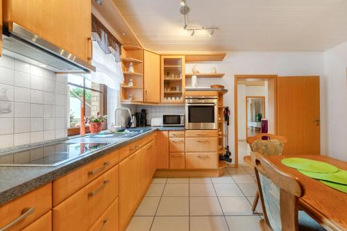 a large kitchen with wooden cabinets and a table at Fewo Lora in Blankenrath
