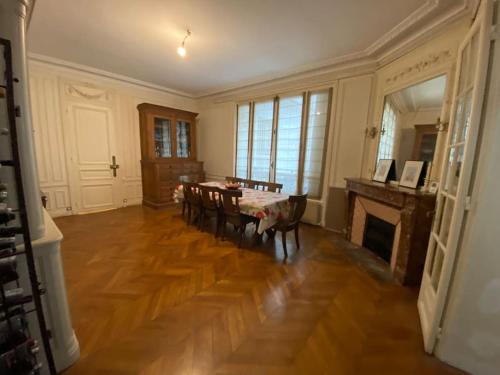 un salon avec une table et des chaises et une cheminée dans l'établissement Paris - Appartement - 16eme, à Paris