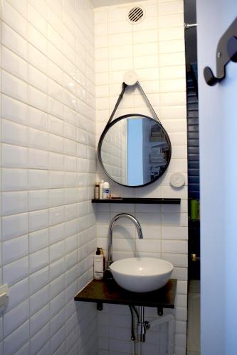 une salle de bain avec un lavabo et un miroir dans l'établissement Charmant deux pièces au coeur du Marais, à Paris