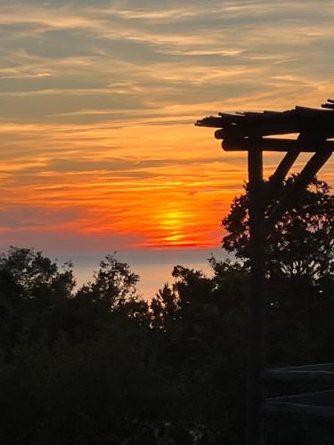 un coucher de soleil avec des arbres et une pergola en bois dans l'établissement Villa BARQUIERO, à Coti-Chiavari