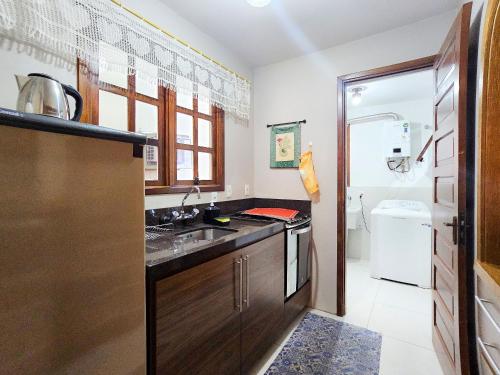 a small kitchen with a sink and a toilet at Ap 2 quartos e varanda na Borges próximo R Coberta in Gramado