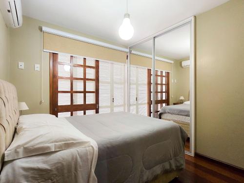 a bedroom with two beds and a large window at Ap 2 quartos e varanda na Borges próximo R Coberta in Gramado