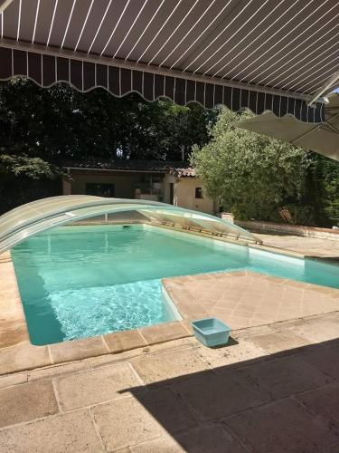 - une grande piscine avec un parasol dans la cour dans l'établissement chambre sur mezzanine salon cuisine d'été extérieure piscine, à Coufouleux