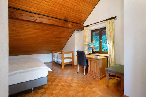 a bedroom with a bed and a desk and a chair at Amadeus Black Forest Mountain in Todtmoos