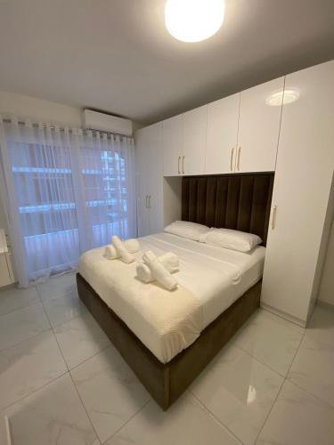 a bedroom with a large bed with white sheets and pillows at Beach house in Shëngjin
