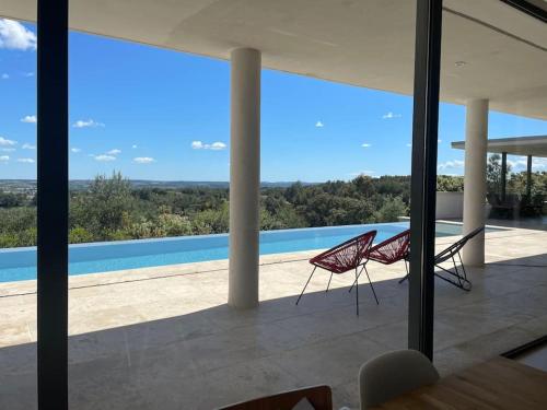 - deux chaises assises sur le balcon d'une maison dans l'établissement Maison californienne Nîmes, à Nîmes