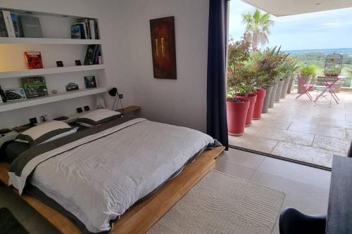 - une chambre avec un lit et une vue sur une terrasse dans l'établissement Maison californienne Nîmes, à Nîmes