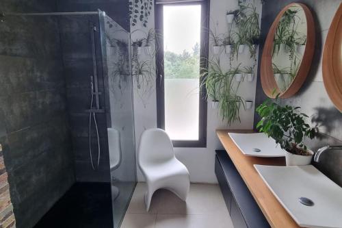 La salle de bains est pourvue d'une douche et d'une chaise blanche. dans l'établissement Maison californienne Nîmes, à Nîmes