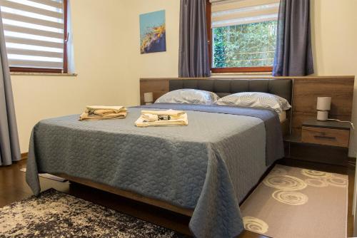 a bedroom with a bed with two robes on it at Apartment Garden Korana Karlovac in Karlovac