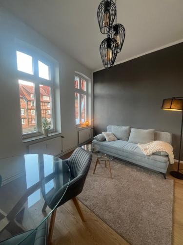 シュターデにあるZeitapartments Am Fischmarktのソファとガラスのテーブルのあるリビングルーム