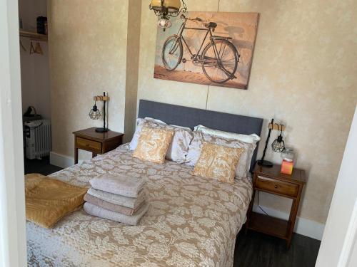 - une chambre avec un lit et un vélo sur le mur dans l'établissement Maison Les Berrys, à Bourganeuf