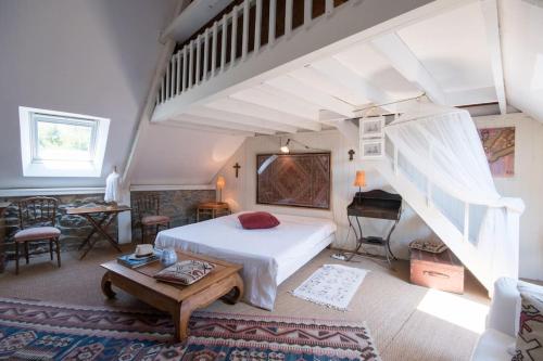 - une chambre avec un lit blanc et un piano dans l'établissement Le Clos Saint Jacques, à Plurien