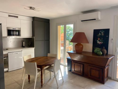 Il comprend une cuisine avec une table et des chaises en bois ainsi qu'un bureau. dans l'établissement Maison Sainte Catherine, aux Salles-sur-Verdon