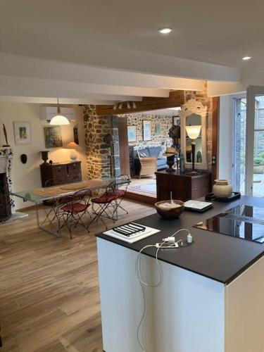 - une cuisine et un salon avec un comptoir et une table dans l'établissement Le Clos Saint Jacques, à Plurien