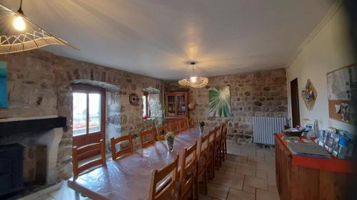 une salle à manger avec une longue table et des chaises dans l'établissement Les Chambres d'Hôtes Le Triskèle, à Rochepaule