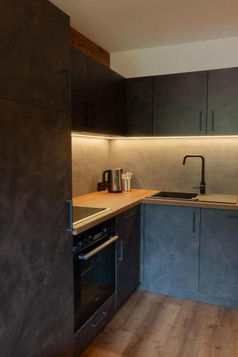a kitchen with darkcolored cabinets and a stove at Haus Barbara in Alpbach
