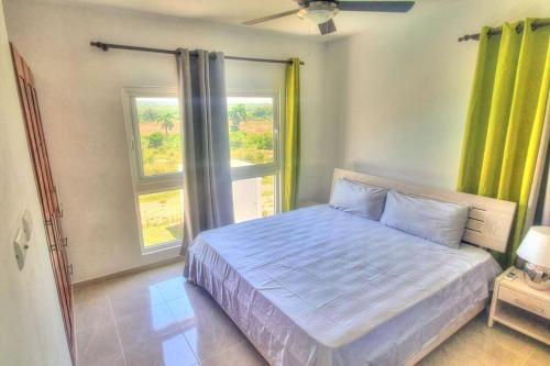 a bedroom with a large bed with a window at 2 Bedroom Pool Villa in Gated Encuentro Residences by Palm Hills Real Estate in Cabarete