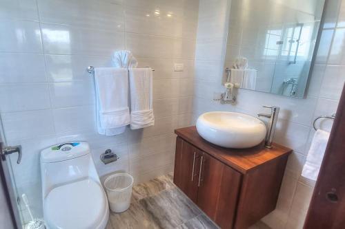 a bathroom with a sink and a toilet at 2 Bedroom Pool Villa in Gated Encuentro Residences by Palm Hills Real Estate in Cabarete