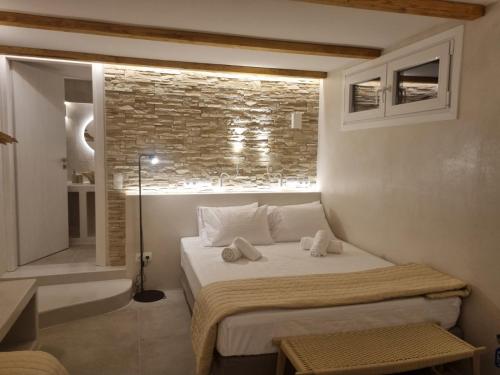 a bedroom with a bed and a brick wall at Golden Star in Ios Chora