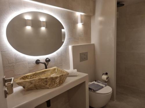 a bathroom with a sink and a mirror and a toilet at Golden Star in Ios Chora