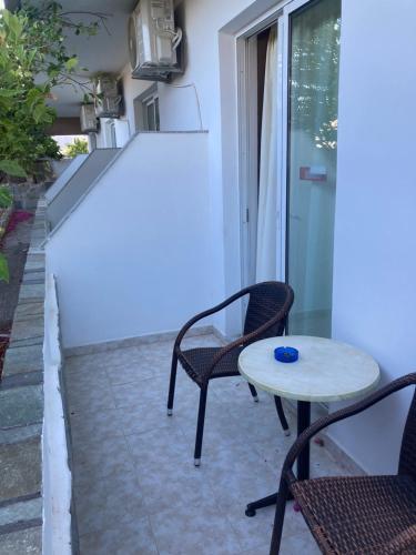 a patio with two chairs and a table at Cannon Guesthouse Faliraki in Faliraki