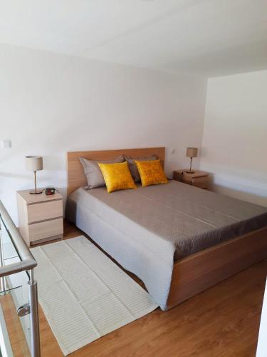 a bedroom with a large bed with yellow pillows at A Toca dos Coelhos in Mogadouro