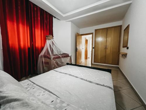 a bedroom with a bed and a red curtain at Enjoy Your Vacation Here, 1 min to The Beach, Only for families !! in Martil