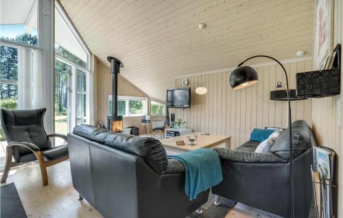 a living room with two leather chairs and a table at Amazing Home In Rødby With Sauna in Rødby