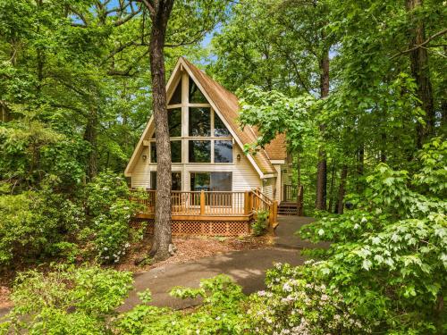 a home in the woods with a large window at Honey Bear - Unique Boutique Chalet in Gatlinburg with Mt Leconte view in Gatlinburg