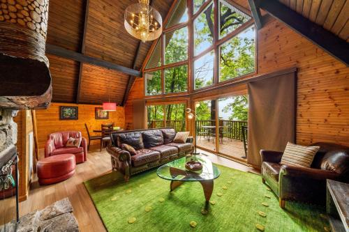 a living room with leather furniture and a large window at Honey Bear - Unique Boutique Chalet in Gatlinburg with Mt Leconte view in Gatlinburg