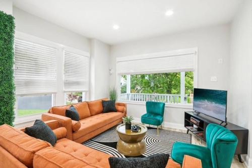 a living room with a couch and chairs and a television at Historic Home in Brewers Hill with hot tub! in Milwaukee
