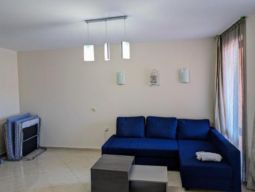 a living room with a blue couch and a tv at SUNNY Star Dreams CONDO w PRIME LOCATION, POOL, SEA VIEW in Sveti Vlas
