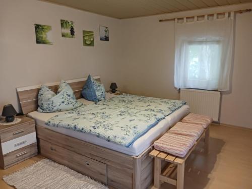 a bedroom with a bed with blue pillows and a window at Ferienwohnung Lücking im Westerwald in Flammersfeld