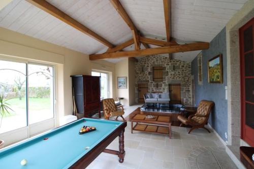 - un salon avec un billard et une cheminée dans l'établissement La Durandière, à Le Puy-Saint-Bonnet