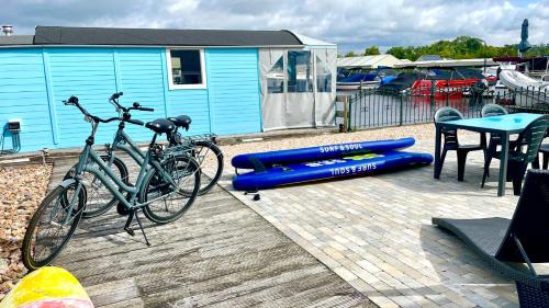 a bike parked on a deck with a table and a blue building at Island Sleeping in Aalsmeer