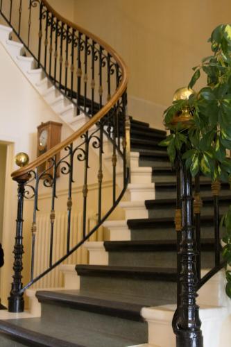 a staircase with black and white railings and a plant at Best Western Grand Hotel de Paris & Spa in Villard-de-Lans