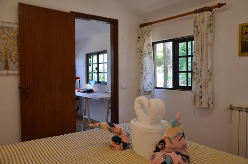two dolls sitting on a bed in a bedroom at Quinta de São Pedro in Sobreda