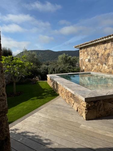 - une piscine dans un mur en pierre à côté d'une maison dans l'établissement Les Bergeries de Pinarello, Arba Barona, à Mangialla