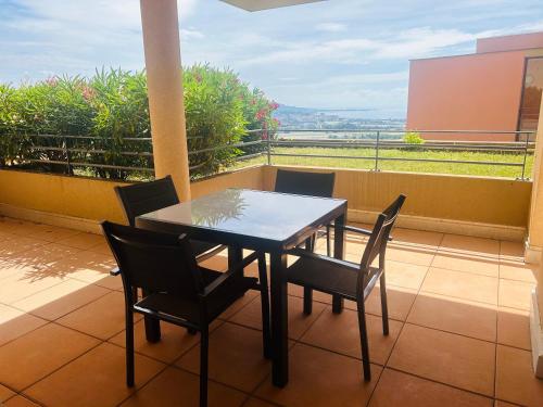 une table et des chaises sur un balcon avec vue dans l'établissement Joli appartement - Terrasse vue mer, à Mandelieu-la-Napoule