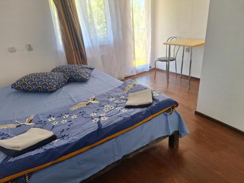 a bedroom with a bed with a blue comforter at Casa Claudiu in Măgura