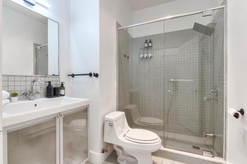 a bathroom with a toilet and a sink and a shower at Take a break in a modern loft on Plateau-Mont-Royal in Montréal