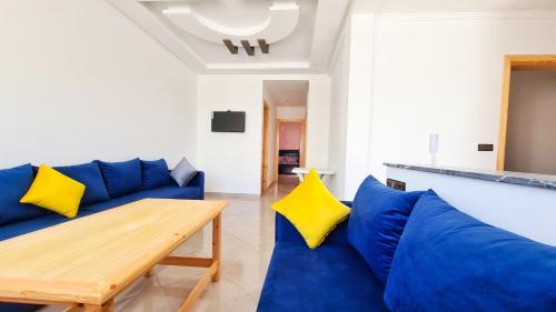 a living room with a blue couch and yellow pillows at Enjoy Your Vacation Here, 1 min to The Beach, Only for families !! in Martil