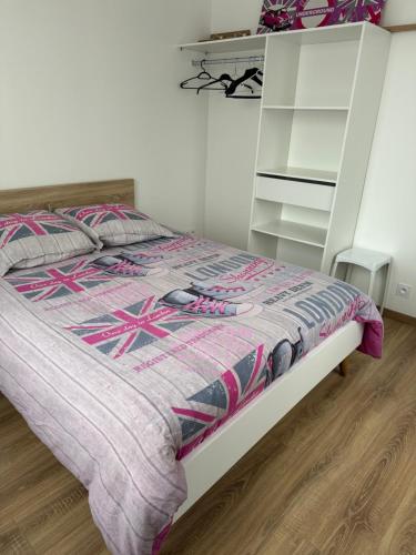 a bedroom with a bed and a white shelf at La petite maison de la gare in Nemours